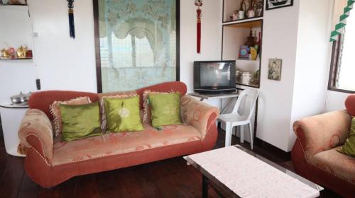 a living room with a couch and a tv at Mangrove Breeze Country Inn by RedDoorz in Del Carmen