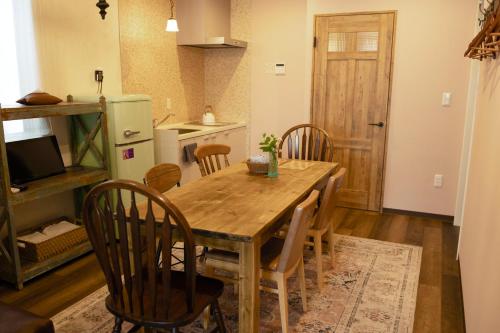 a kitchen and dining room with a wooden table and chairs at 7 Rooms Hotel & Cafe - 30mins from Disneyland in Tokyo