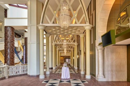 a hallway of a building with columns and a chandelier at Sheraton Imperial Kuala Lumpur Hotel in Kuala Lumpur
