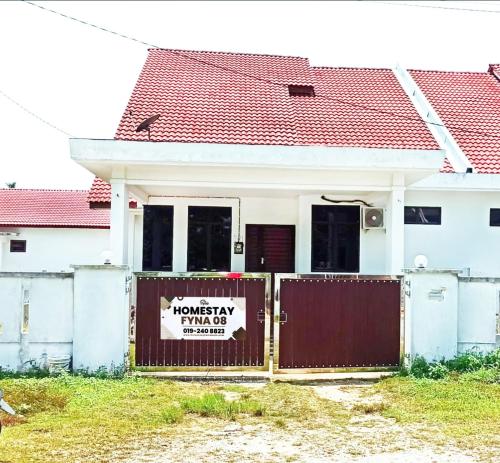 a house with a fence with a sign on it at Homestay Kemaman Fyna08 Semi-D, 4 Bedrooms Dekat Pantai Kijal in Kijal