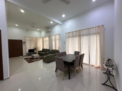 a living room with a dining table and a couch at Homestay Kemaman Fyna08 Semi-D, 4 Bedrooms Dekat Pantai Kijal in Kijal
