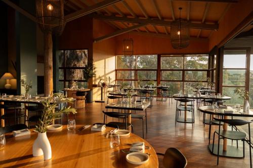 a restaurant with tables and chairs and windows at Mimosa Wines in Murrah