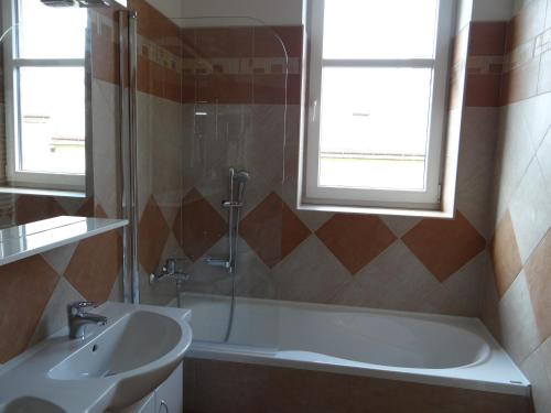 a bathroom with a tub and a sink and a window at Penzion 324 in Štoky
