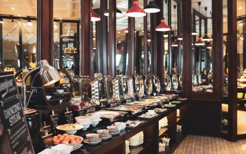 a buffet line with plates of food in a store at Alagon D'antique Hotel & Spa - Wellness Treatment Included in Ho Chi Minh City