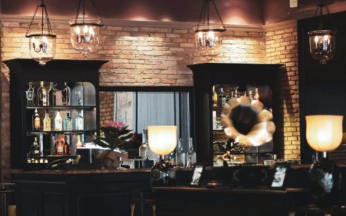 a bar with a counter and a window and lights at Alagon D'antique Hotel & Spa - Wellness Treatment Included in Ho Chi Minh City