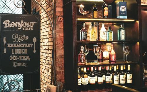 a bar with a shelf full of bottles of alcohol at Alagon D'antique Hotel & Spa - Wellness Treatment Included in Ho Chi Minh City