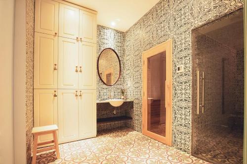 a bathroom with a sink and a mirror at Alagon D'antique Hotel & Spa - Wellness Treatment Included in Ho Chi Minh City