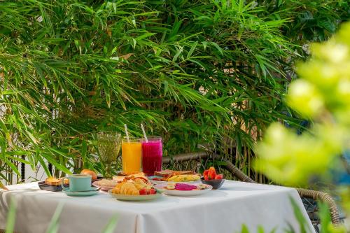 a table with plates of food and drinks on it at Alagon D'antique Hotel & Spa - Wellness Treatment Included in Ho Chi Minh City