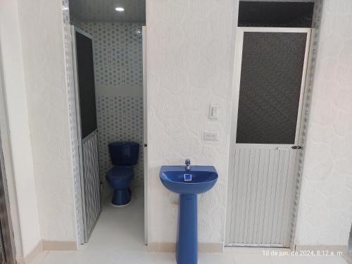 a bathroom with a blue sink and a toilet at Casa Valentina habitación#2 para 6 personas in Guamo