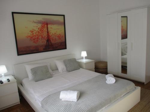a bedroom with a white bed with a picture on the wall at Centro Cidade Holiday in Portimão