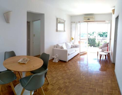 a living room with a table and chairs and a couch at Departamento en San Isidro in Acassuso
