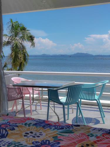 a table and chairs with a view of the ocean at มารินอส บีชเฮ้าส์ Marinos Beach house in Si Racha