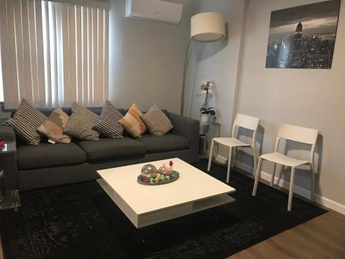 a living room with a couch and a table and chairs at 30 mins to TIMES SQ!!!! in Corona