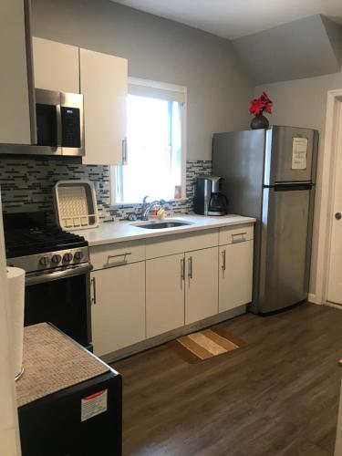 a kitchen with white cabinets and a stainless steel refrigerator at 30 mins to TIMES SQ!!!! in Corona