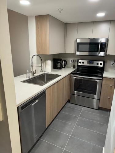 a kitchen with a sink and a microwave at Beautiful 1BR 1BA Apartment at NORTHSTAR-Whistler, BC in Whistler