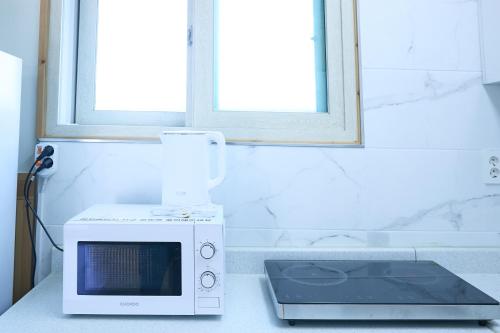 a microwave sitting on a counter next to a window at Ronnie Pension in Taean