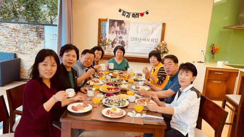 a group of people sitting around a table eating food at Astana Villa Non Nuoc Beach in Da Nang
