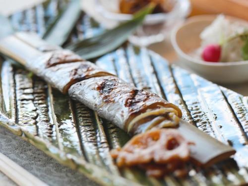 a wrapped food item on a plate on a table at Bettei Wankobiyori in Ashikita
