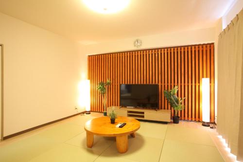 a living room with a table and a television at 大阪ルミエール夕陽丘 in Osaka