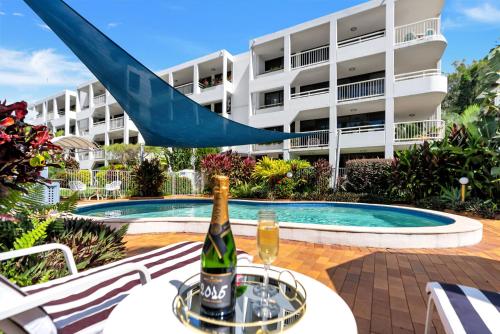 a bottle of champagne on a table in front of a building at Argosy On The Beach in Clifton Beach