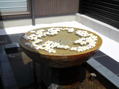 a bowl with white flowers on top of it at Bettei Wankobiyori in Ashikita