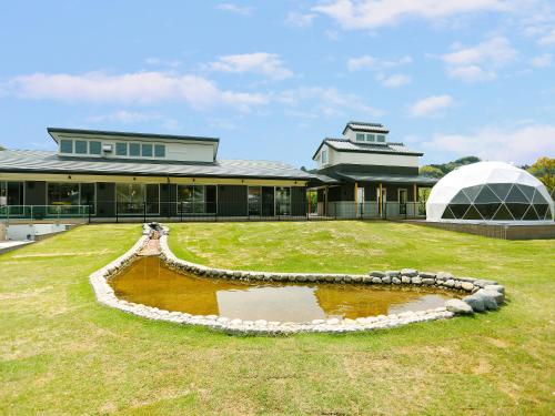 a large building with a pond in front of it at Bettei Wankobiyori in Ashikita