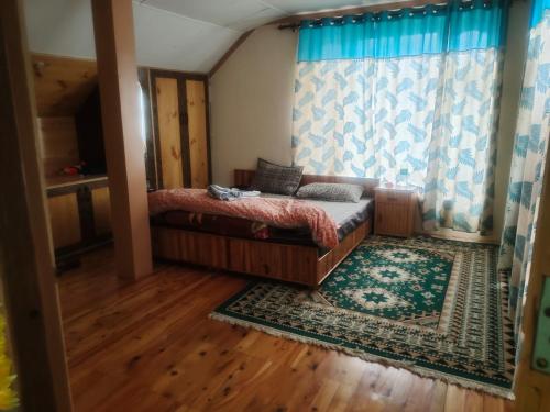 a bedroom with a bed and a window and a rug at Manepa Homestay Kardang in Kyelang