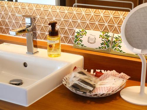 a bathroom counter with a sink and a mirror at Bettei Wankobiyori in Ashikita