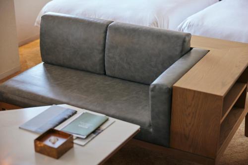 a couch with a table with a book on it at NOHGA HOTEL AKIHABARA TOKYO in Tokyo