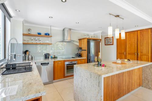 a large kitchen with wooden cabinets and a counter top at Argosy On The Beach in Clifton Beach