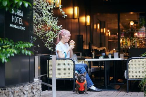 a woman sitting in a chair with a dog at NOHGA HOTEL AKIHABARA TOKYO in Tokyo