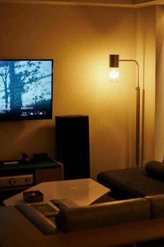 a living room with a couch and a flat screen tv at NOHGA HOTEL AKIHABARA TOKYO in Tokyo