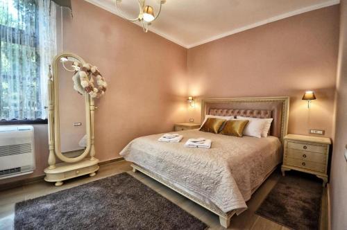 a bedroom with a large bed and a mirror at QUEEN MARIA Apartments in Demir Kapija
