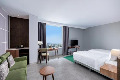 a hotel room with a bed and a desk at Swiss-Belinn Bogor in Bogor