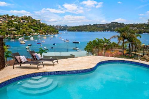 a swimming pool with a view of a harbor and boats at World Class Villa Manly Beach HarbourView Sauna Private Beach in Sydney