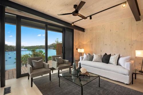 a living room with a white couch and chairs at World Class Villa Manly Beach HarbourView Sauna Private Beach in Sydney