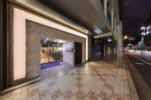 an empty sidewalk in a city at night at Nipponbashi Crystal Hotel in Osaka