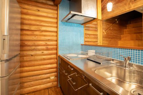 a kitchen with a sink and a refrigerator at 森の糸島 - Morino Itosima in Nishinoura