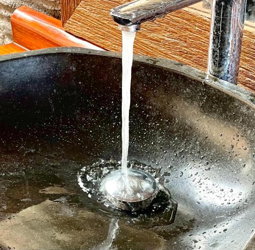a stream of water pouring into a sink at JANE’S HOUSE & SPA BEDUGUL BALI in Patjung