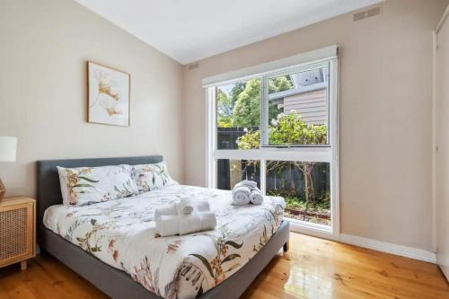 a bedroom with a bed and a large window at The Alcove Ballarat in Ballarat