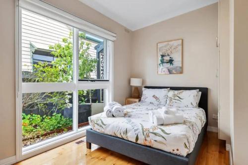 a bedroom with a bed and a large window at The Alcove Ballarat in Ballarat