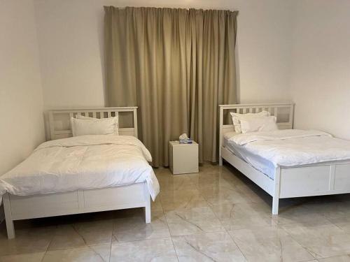 zwei nebeneinander stehende Betten in einem Schlafzimmer in der Unterkunft Moonlight Resort in Sinādil