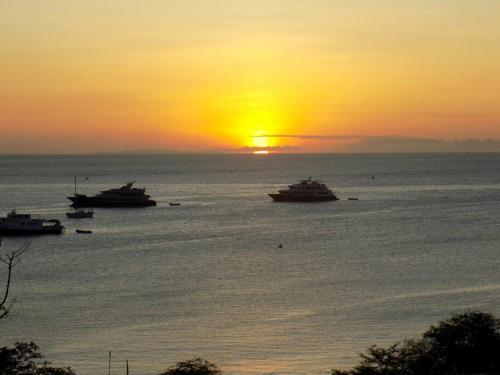 a group of boats in the water at sunset at Suite Brisa del Mar - Cabañas Don Jorge in San Cristobal