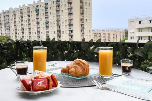 - une table avec un plateau de nourriture et 2 verres de jus d'orange dans l'établissement Appartement T3 parking à 5 minutes a pied du stade vélodrome, à Marseille