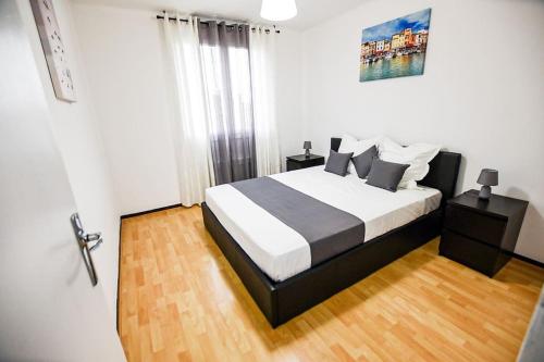 - une chambre avec un lit noir et blanc et du parquet dans l'établissement Appartement T3 parking à 5 minutes a pied du stade vélodrome, à Marseille