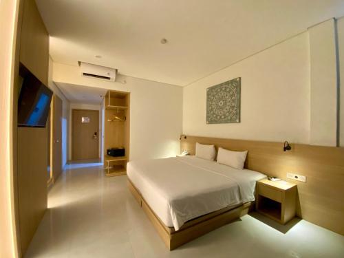 a bedroom with a large white bed in a room at OPI Indah Hotel in Palembang