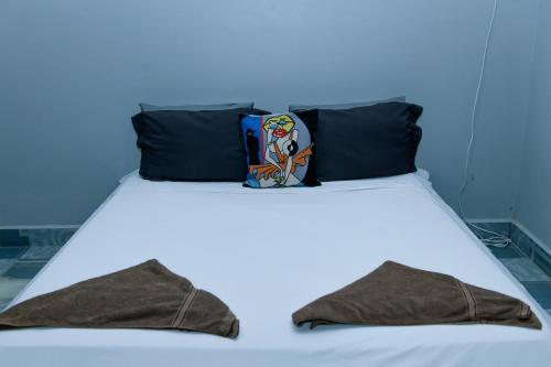 a white bed with two pillows on top of it at Angkor Piseth Homestay in Siem Reap