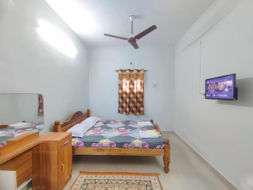 a bedroom with a bed and a ceiling fan at Maison Douce in Chennai