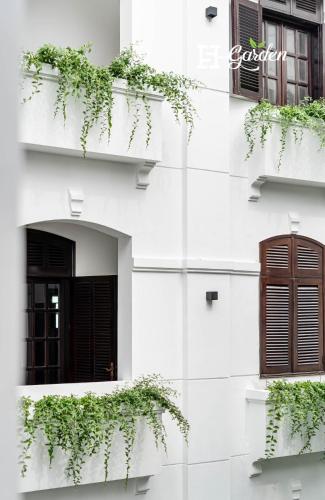 a white building with windows and plants on it at 5H Garden in Ho Chi Minh City