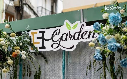 a sign on a fence with flowers on it at 5H Garden in Ho Chi Minh City